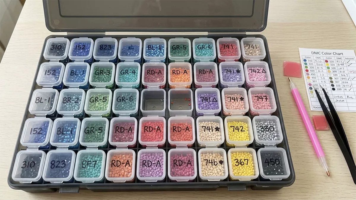 Sorted diamond painting drills in a labelled grid storage box